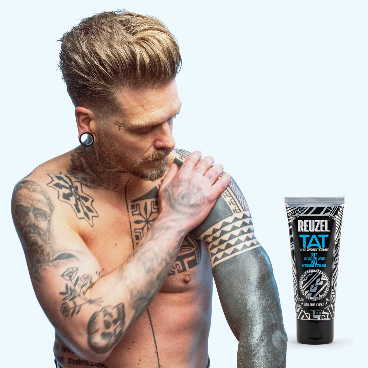 REUZEL UK BUFF Exfoliating Wash for tattoo aftercare, featuring a pump bottle with white and blue label and clear liquid inside.