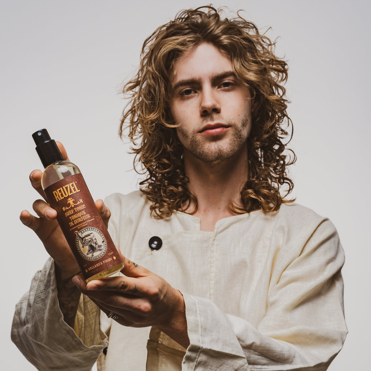Reuzel UK Surf Tonic salt spray bottle with label, designed for beachy, textured hair styling.