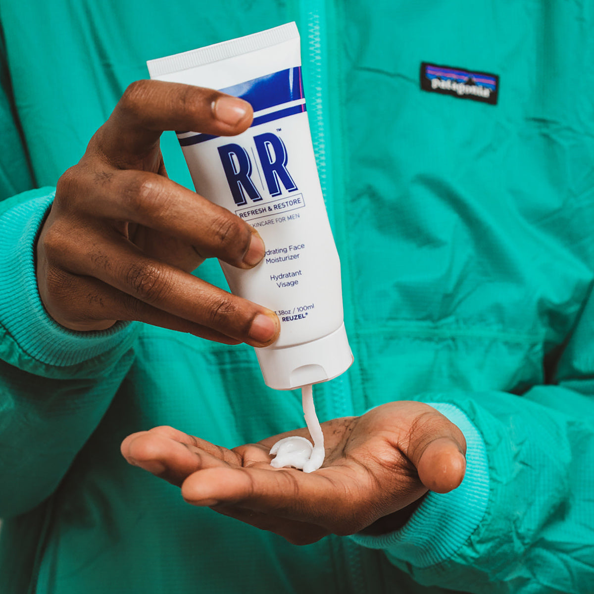 REUZEL UK hydrating face moisturizer in a white jar with a blue label, showing the product's creamy texture on the lid.