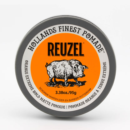 A round tin of Reuzel Holland's Finest Pomade in Orange Extreme, featuring a bright orange label with a black pig illustration and gray outer rim on a white background.