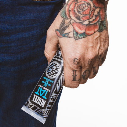 REUZEL UK TAT Duo Buff Exfoliating Wash and Vivid Gel for tattoo aftercare, shown in a sleek packaging with product labels.