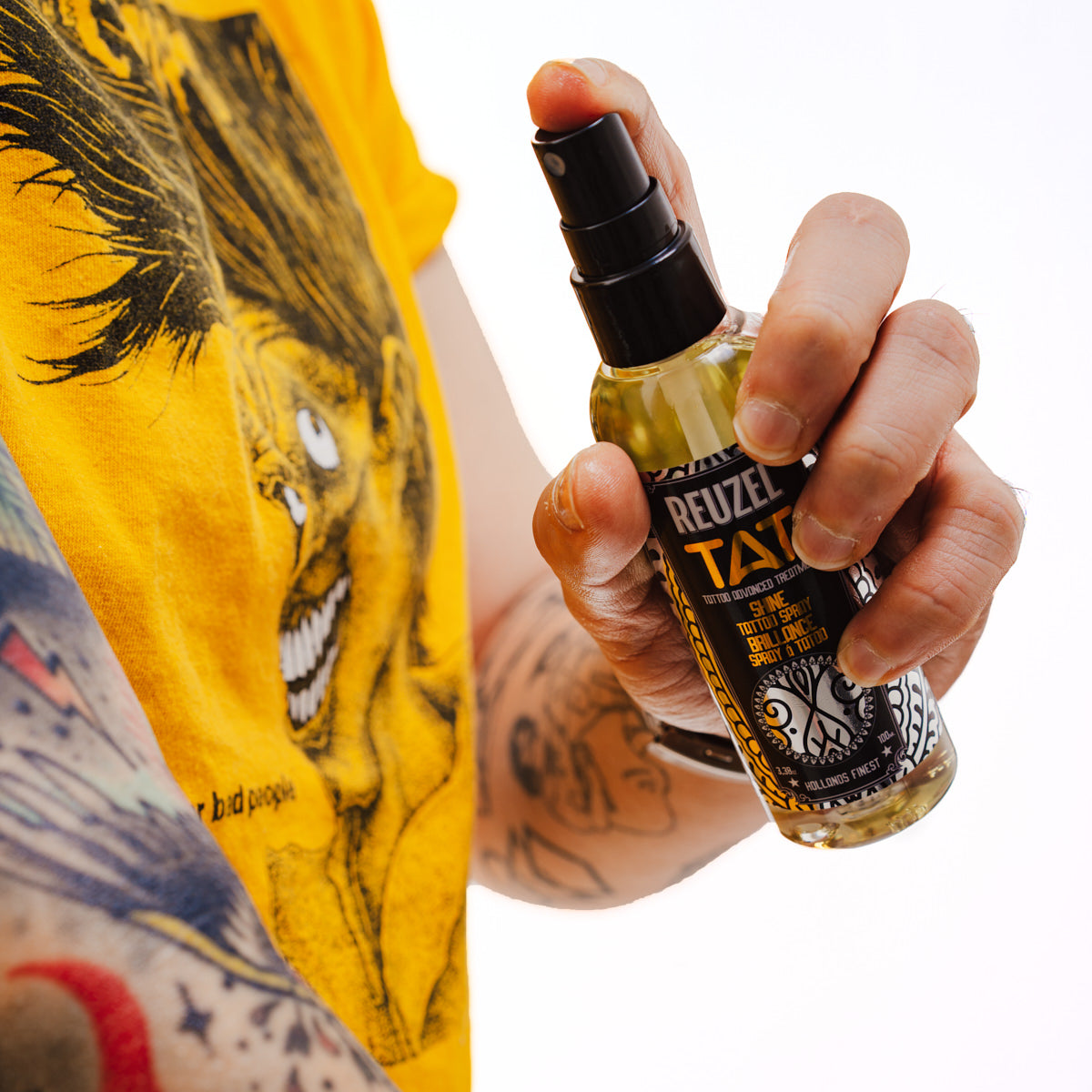 REUZEL UK TAT Trio tattoo aftercare set including BUFF exfoliating wash, SHINE spray, and Vivid gel, with the SHINE spray bottle visible.